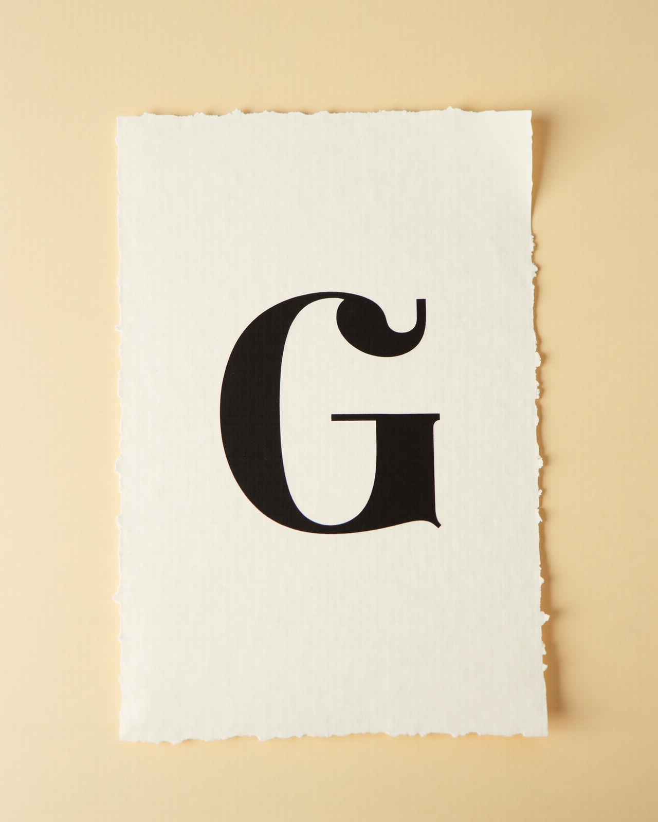 A single black sans-serif capital G printed on newsprint paper