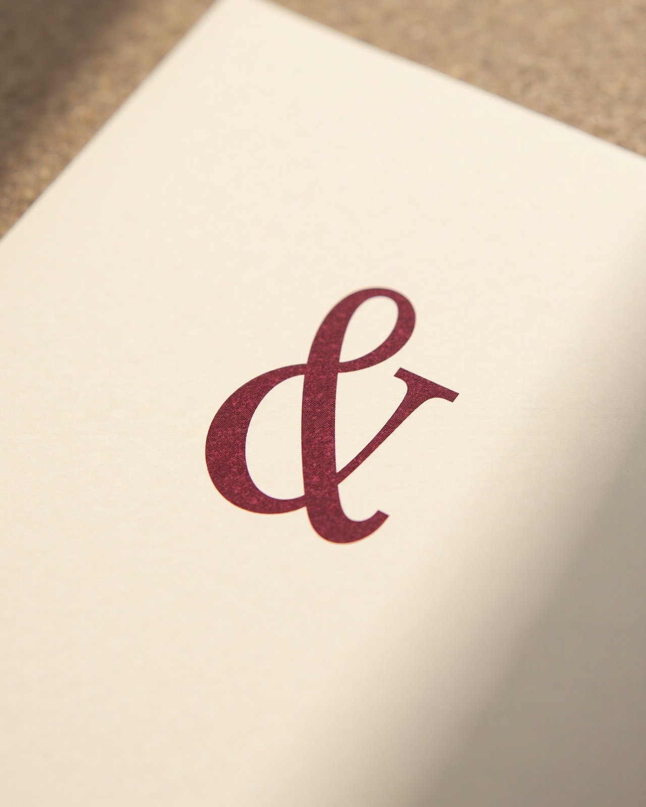 A large italic serif ampersand printed in burgundy ink